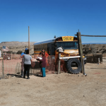 people by a school bus in New Mexico desert