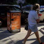 person walking down a sunny street